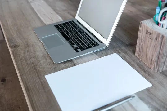 This image shows a notebook and a laptop in a table.